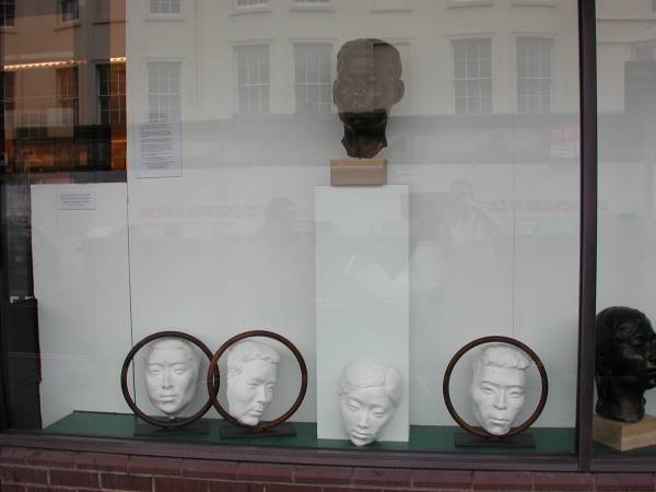 Left section of window in gallery showing sculptures by Laury Dizengremel